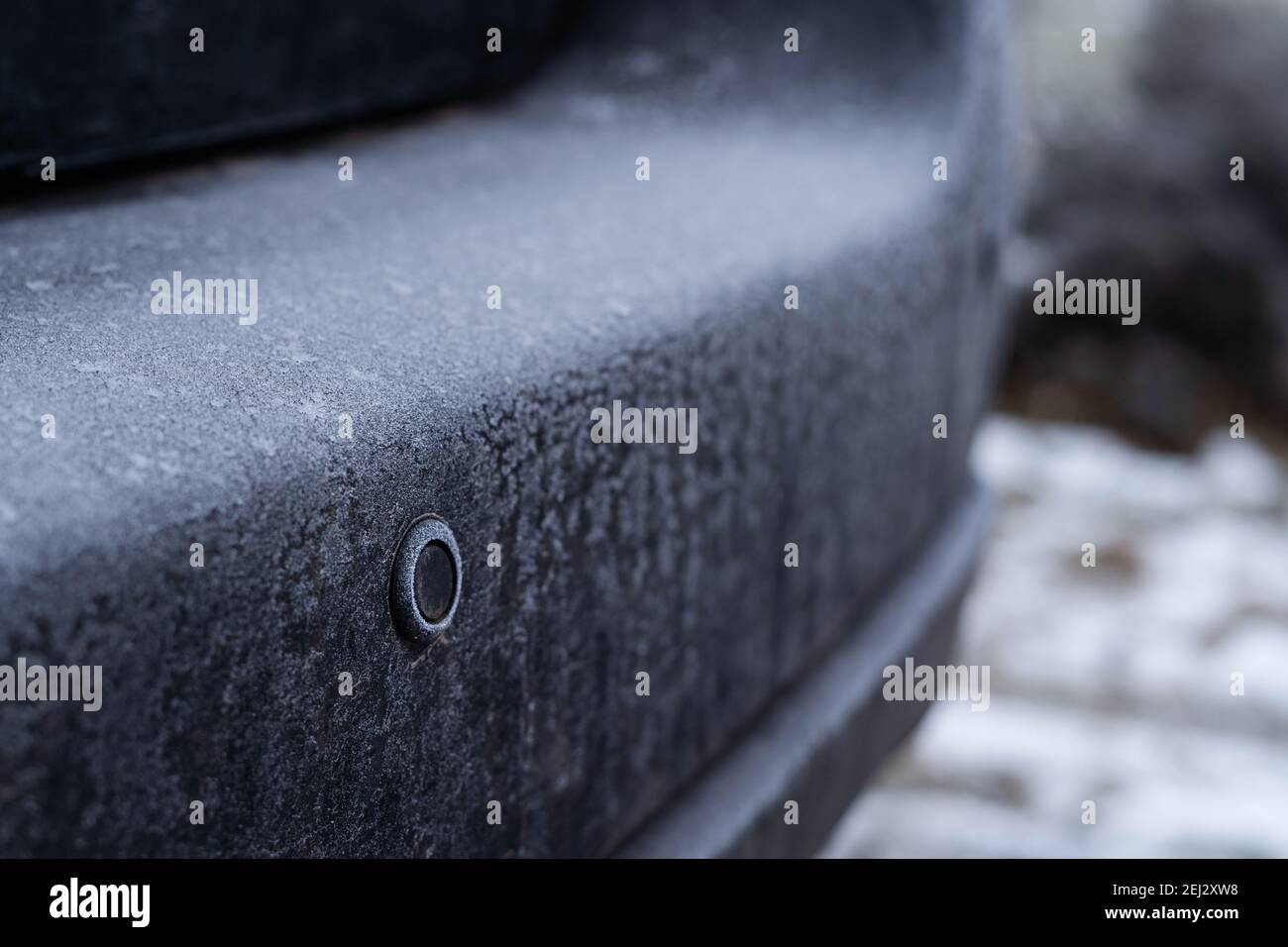 Parktronic sensor of the car covered with frost on the rear bumper in winter Stock Photo