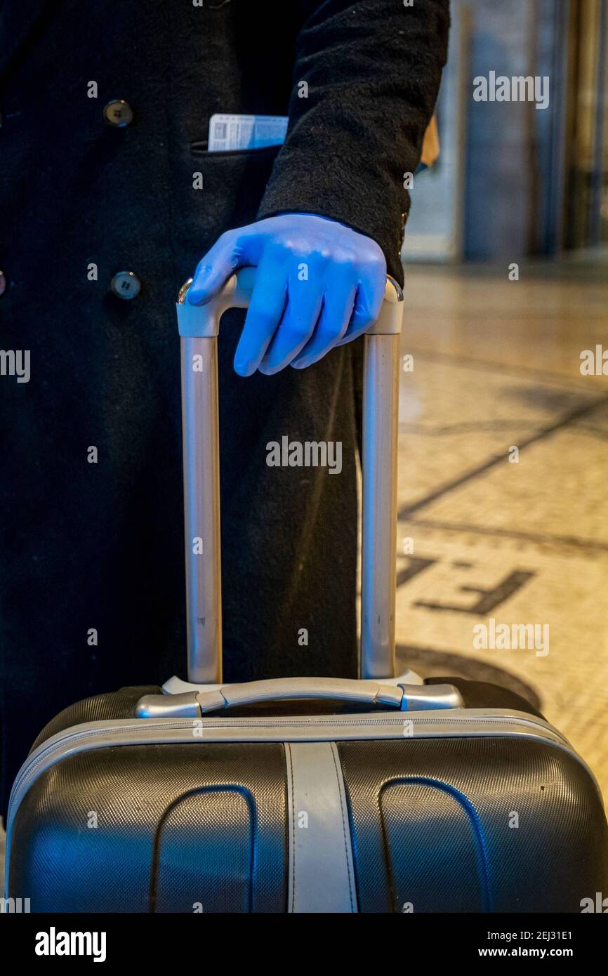 Reportage, Italy. 13th Mar, 2021. 3/13/2021 - Milan - Coronavirus, Milano Centrale Station on the second evening after the new ordinance. A passenger with blue plastic gloves, to avoid contagion (Milan - 2020-03-09, Marco Passaro) ps the photo can be used in compliance with the context in which it was taken, and without the defamatory intent of people's decorum represented Editorial Usage Only (Photo by IPA/Sipa USA) Credit: Sipa USA/Alamy Live News Stock Photo
