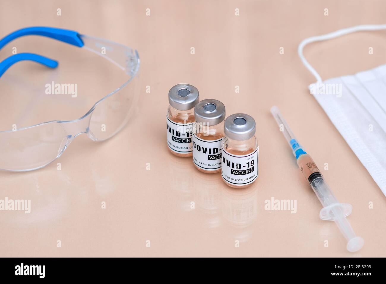 A bottle of of coronavirus vaccine. a dialed syringe on the table.  Stock Photo