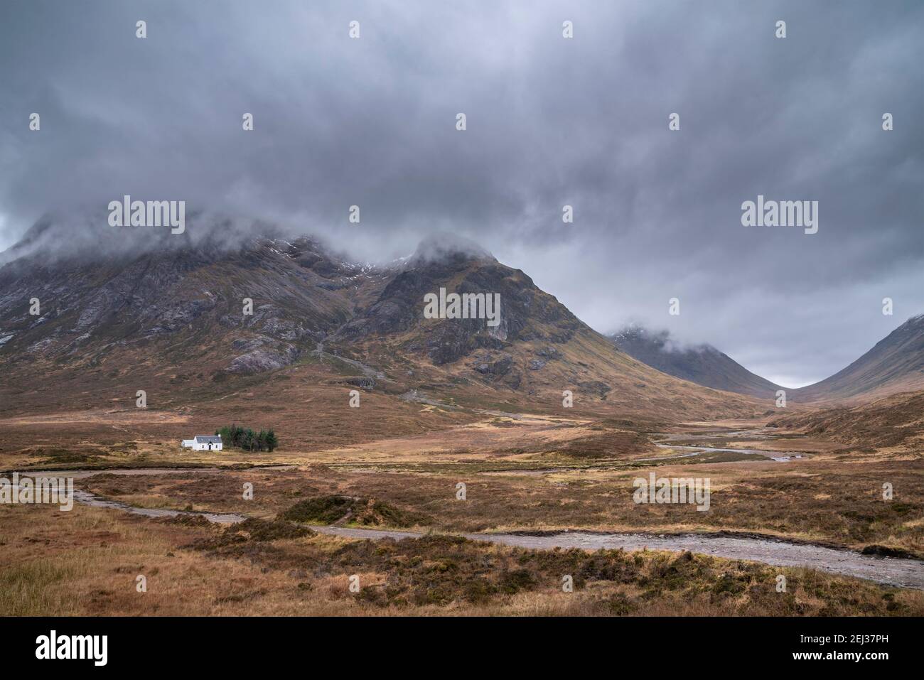 Stunning landscape image view down Glencoe Valley in Scottish Highlands with mountain ranges in dramatic Winter lighting Stock Photo