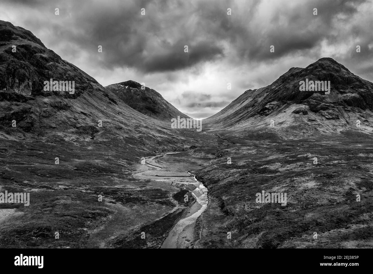 Flying drone dramatic  black and white landscape image of Buachaille Etive Mor and surrounding mountains and valleys in Scottish Highlands on a Winter Stock Photo