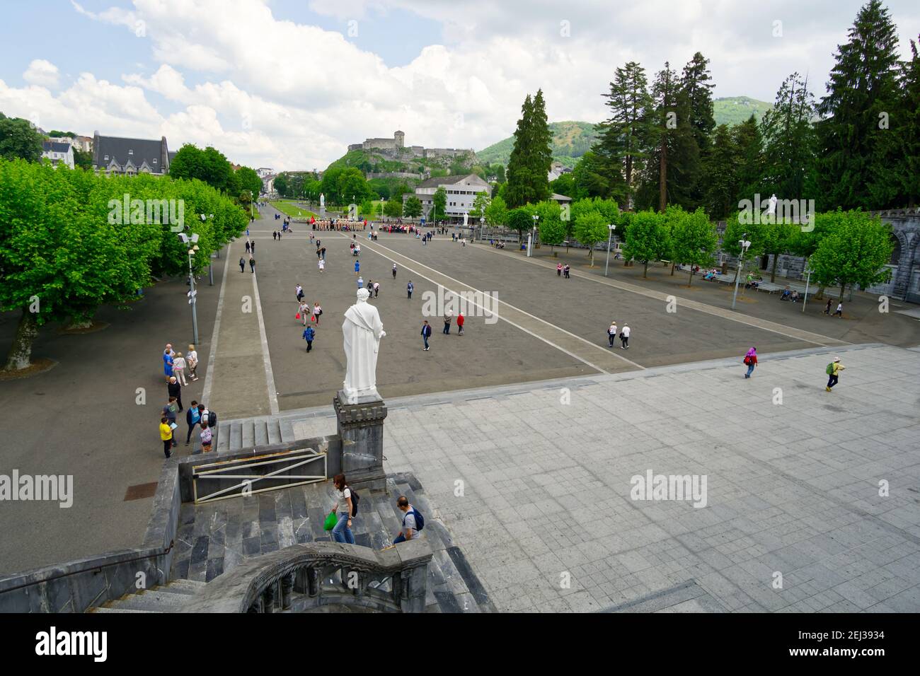 Lourdes, France - 05 2018. Esplanade of the sanctuary of Lourdes with the medieval castle in the background. Stock Photo