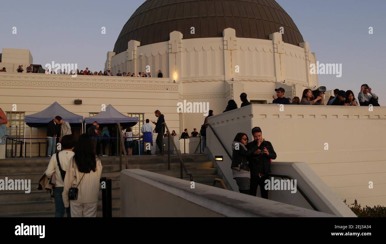 LOS ANGELES, CALIFORNIA, USA - 7 NOV 2019: Griffith observatory viewpoint. Crowd on vista point, people watching sunset over city and Hollywood sign. Stock Photo