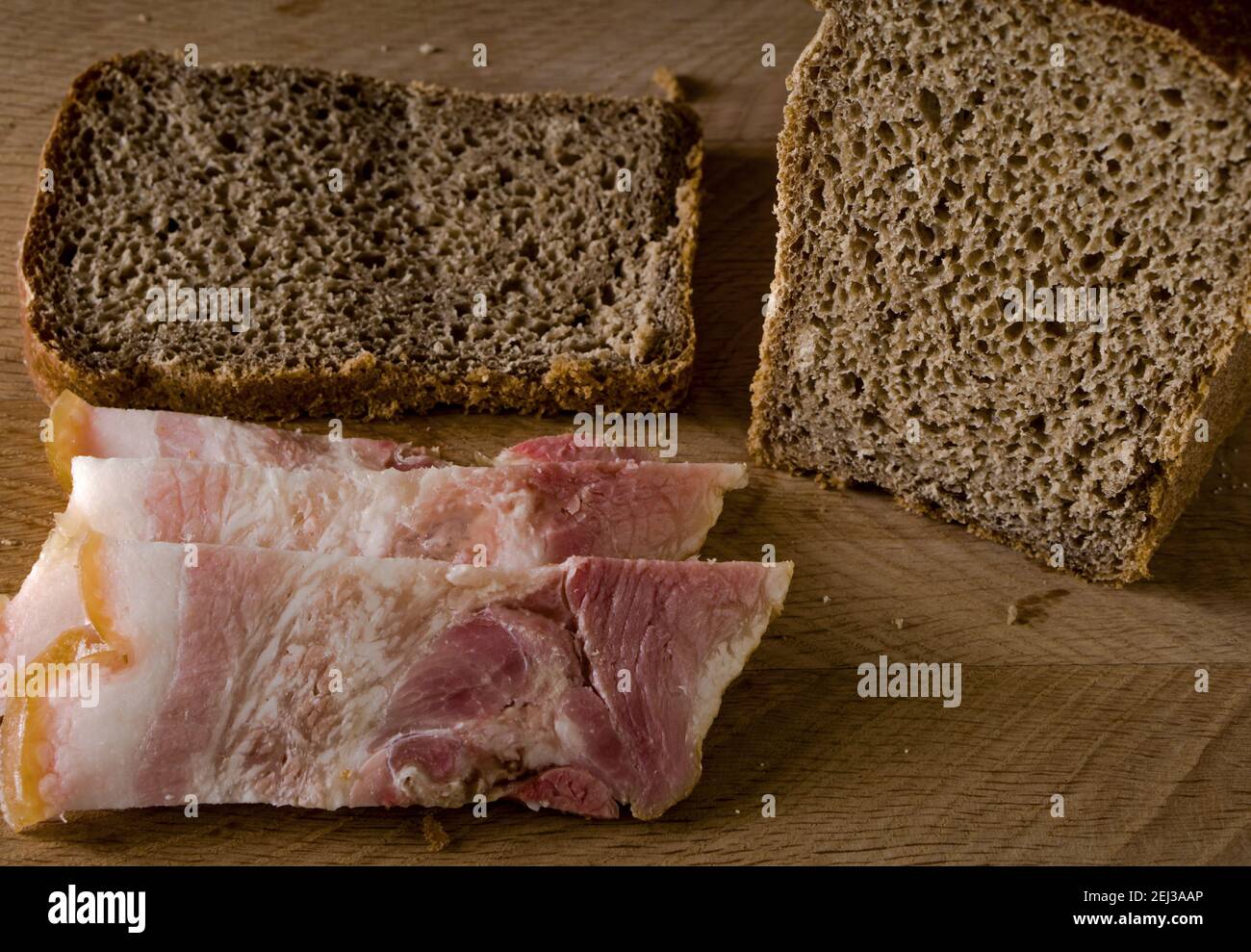 Black bread and salted lard with strips of meat, on a wooden board