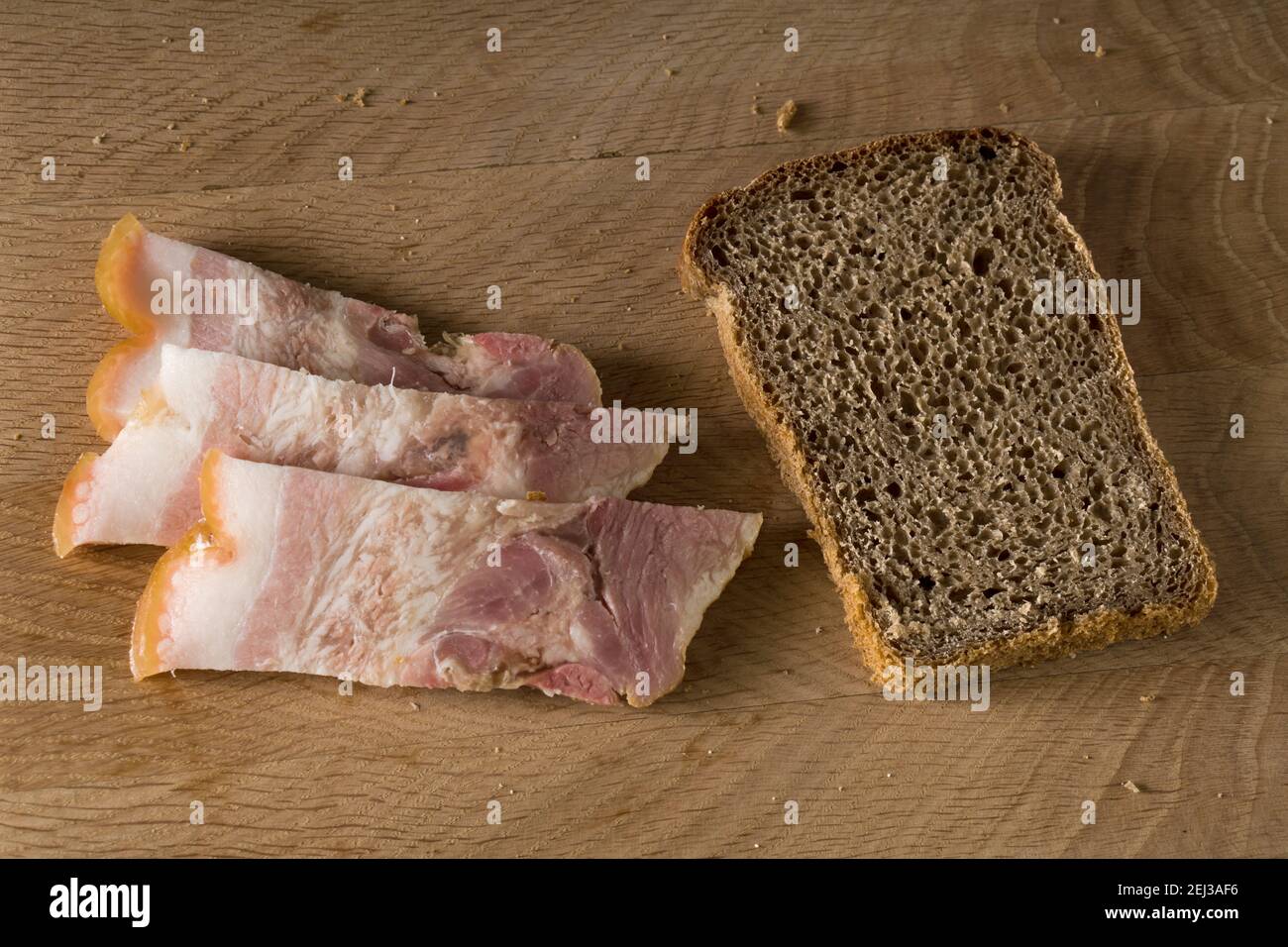 Black bread and salted lard with strips of meat, on a wooden board Stock Photo