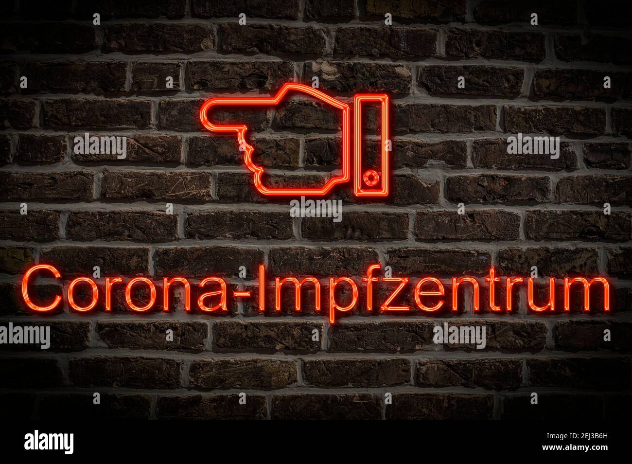 Detailansicht einer Leuchtreklame an einer Mauer mit der Aufschrift Corona Impfzentrum Stock Photo