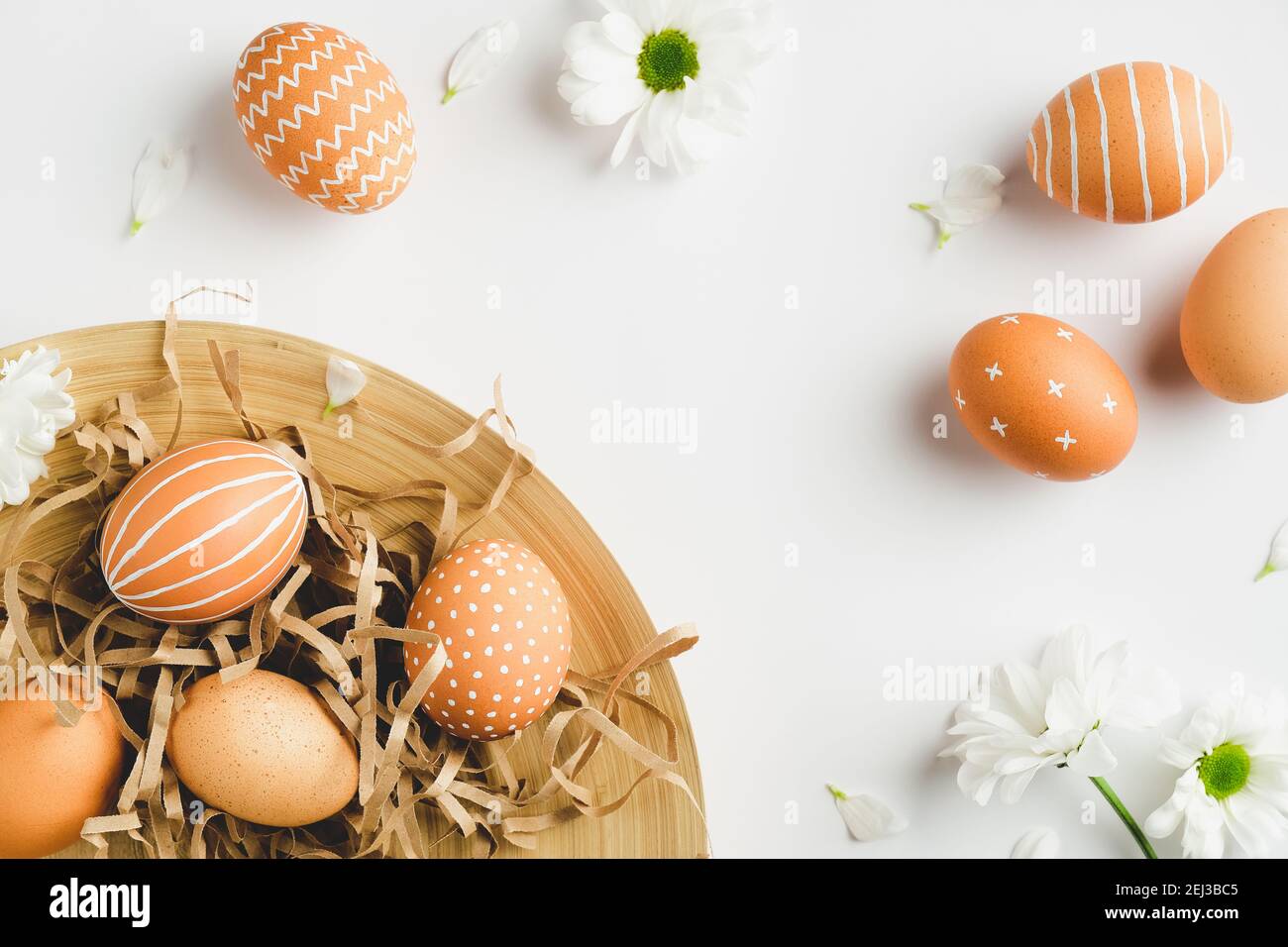 Modern Easter eggs and spring flowers on white background. Flat lay ...