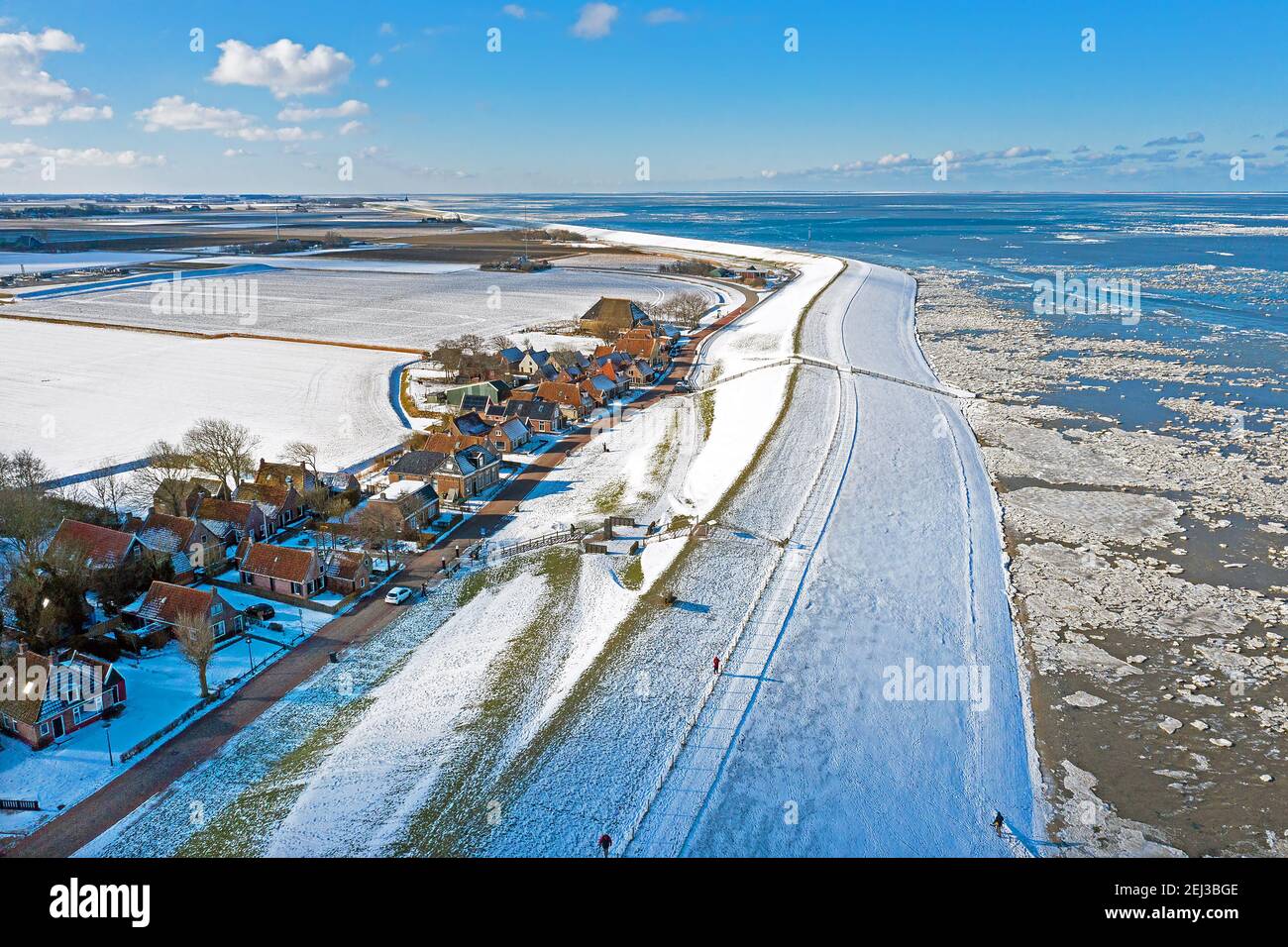 Aerial from the snowy village Moddergat at the frozen Waddensea in winter in the Netherlands Stock Photo