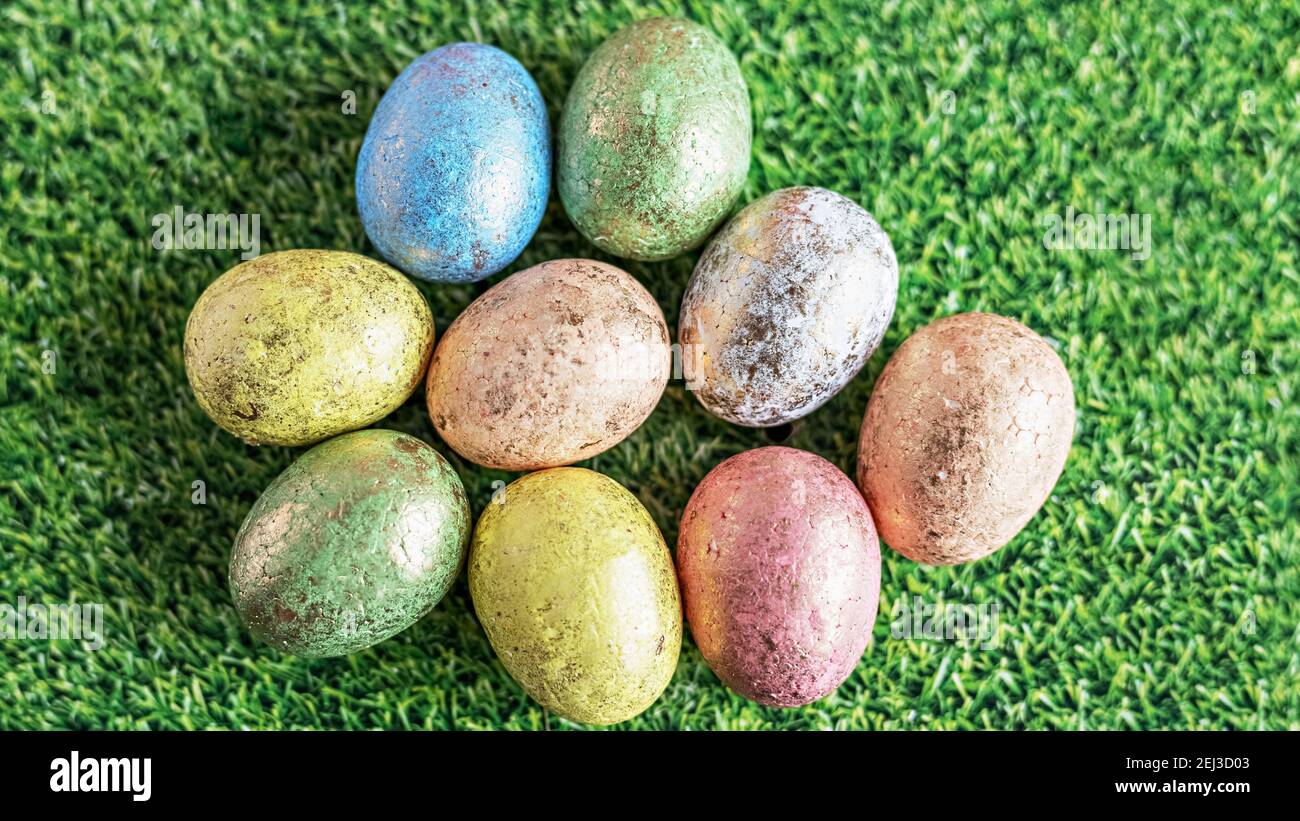 Easter eggs in pastel colors on a green background with grass texture ...