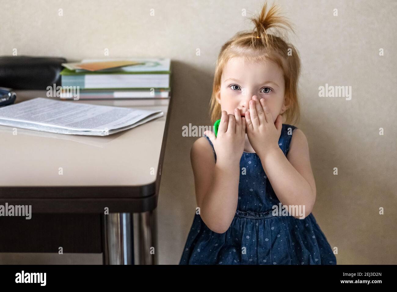 Little girl in the doctor's office at the clinic. Sitting waiting for a pediatrician examination before vaccination. Afraid. Concept of vaccination, i Stock Photo