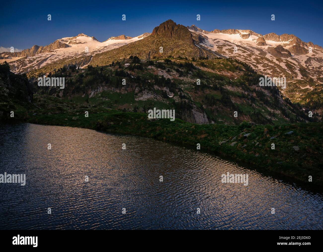 ENG: Aneto summit and the Maladeta massif viewed from Ibón Superior de Villamuerta in a summer sunrise (Benasque valley, Pyrenees, Spain) ESP: Cumbre Stock Photo