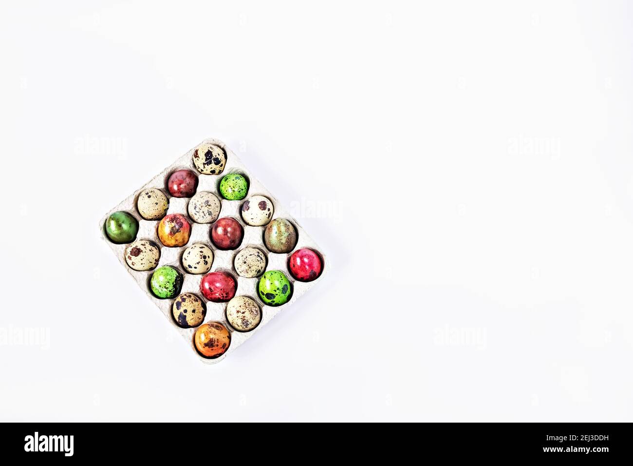 Colored quail Easter eggs in a box on the white background. Easter holiday concept. Stock Photo