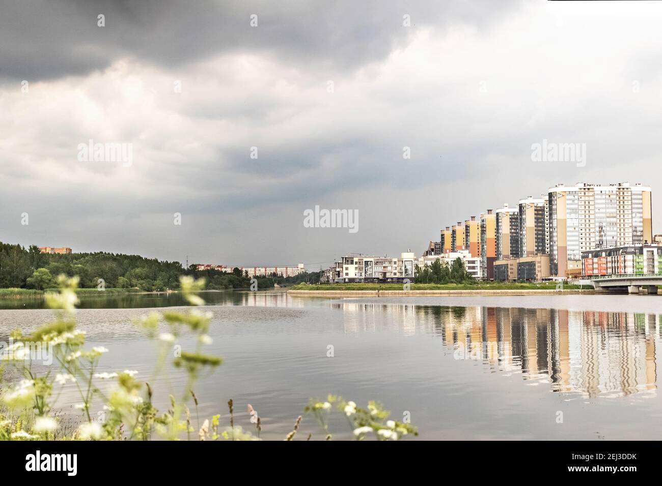 The coast of the Gulf of Finland with modern buildings. Island and parkland on the horizon. Stock Photo
