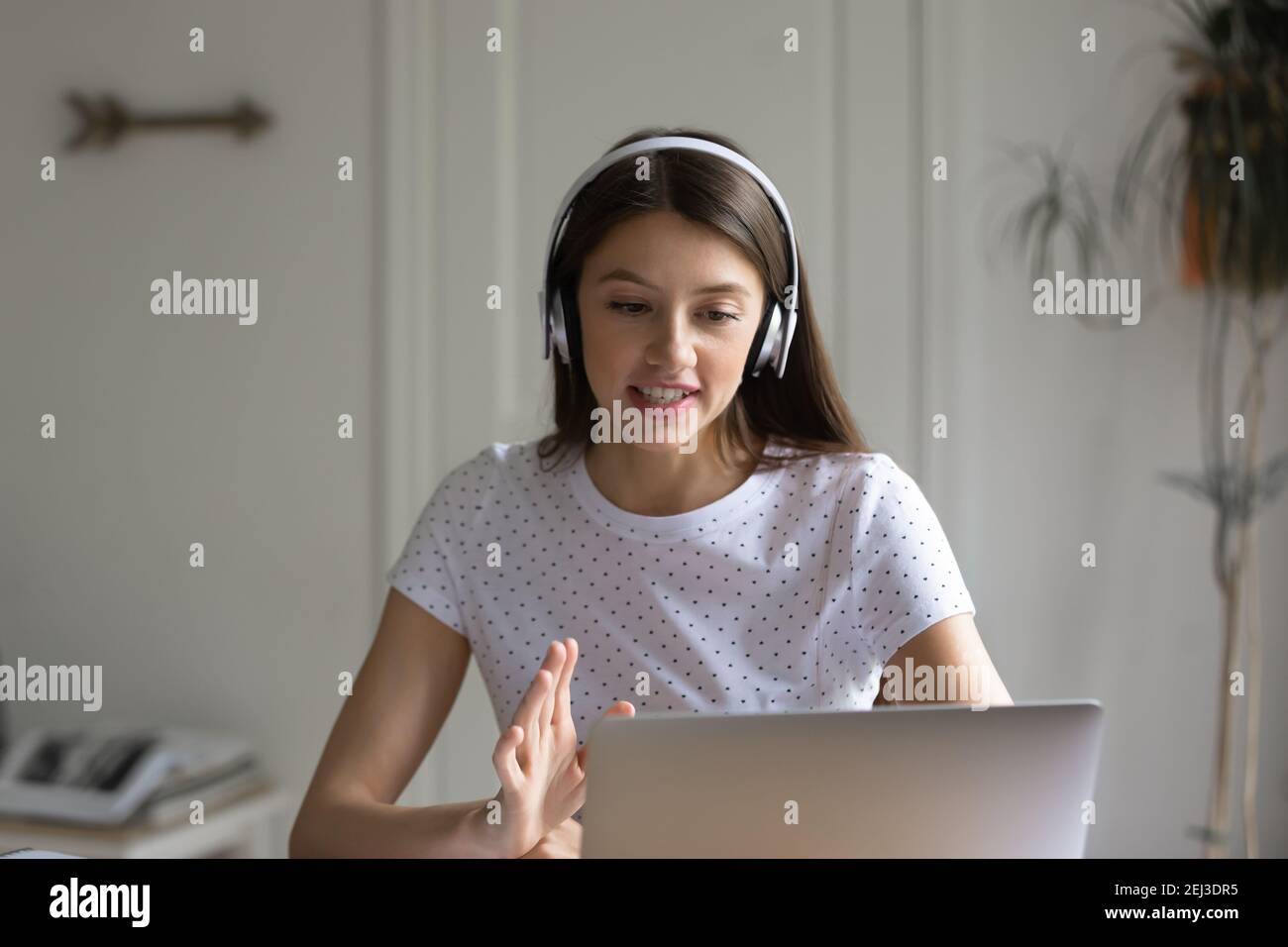 Millennial female in headphones talk on video call Stock Photo - Alamy