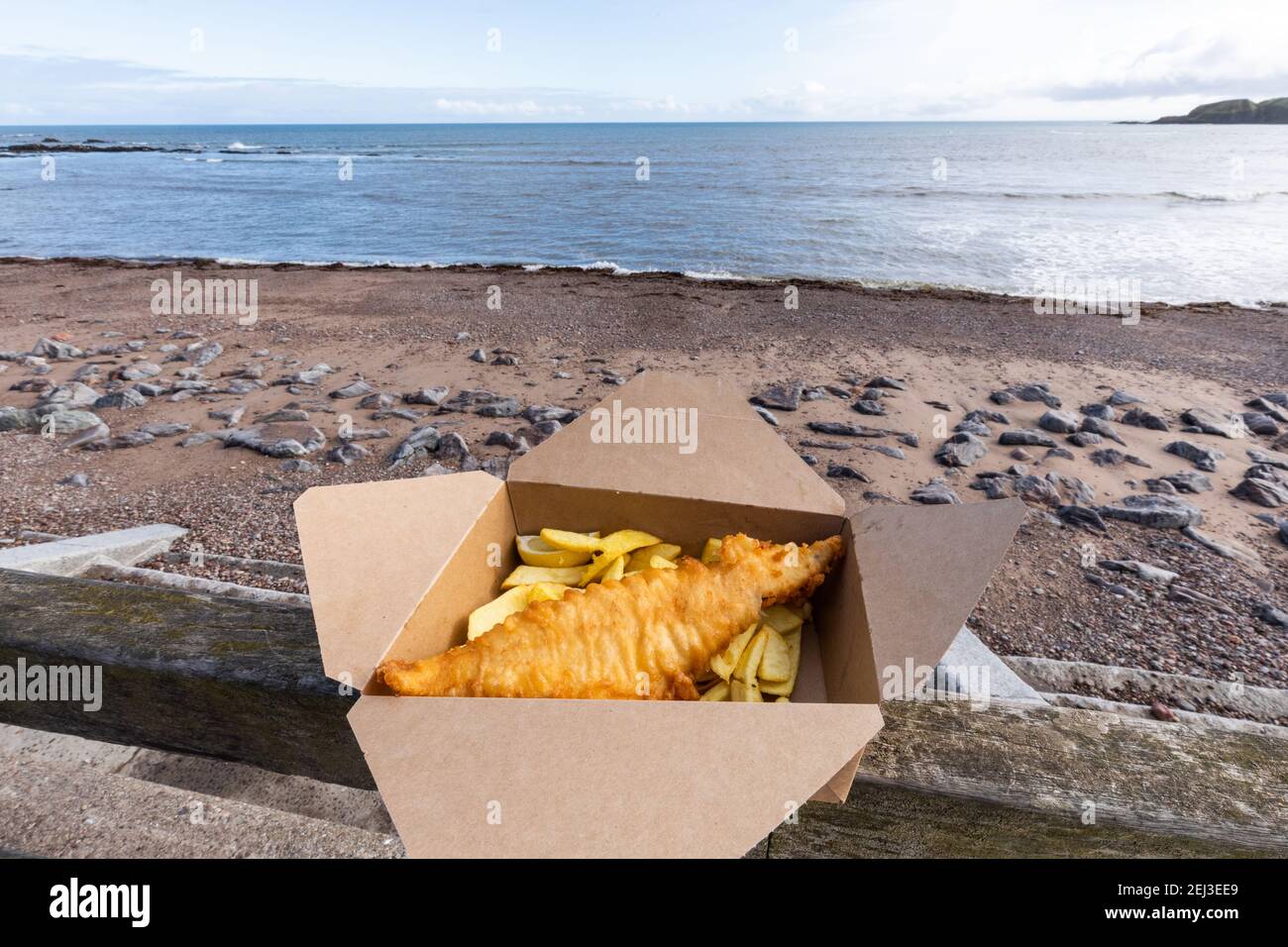 Takeaway fish and chips in a box at the seaside in the UK Stock Photo