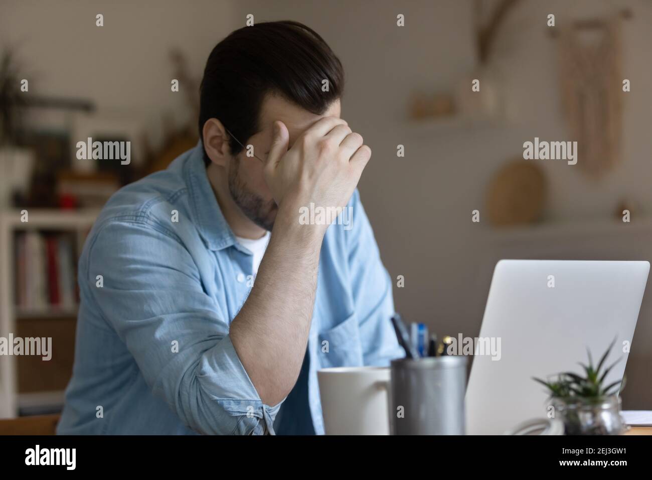 Unhappy man work on laptop having problems Stock Photo