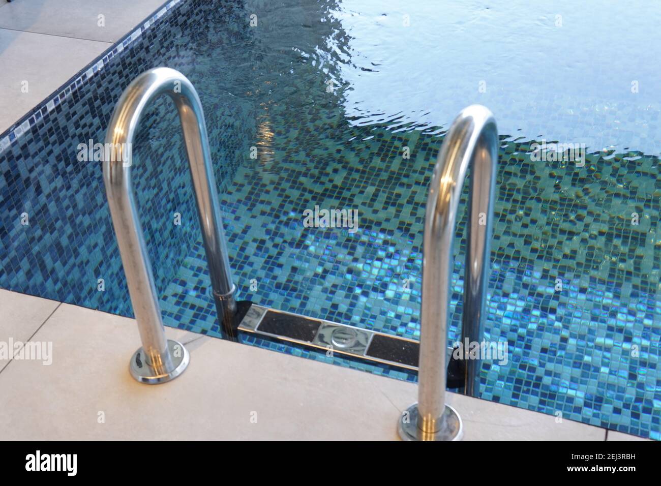 A high angle shot of a stainless steel ladder on a swimming poo Stock Photo