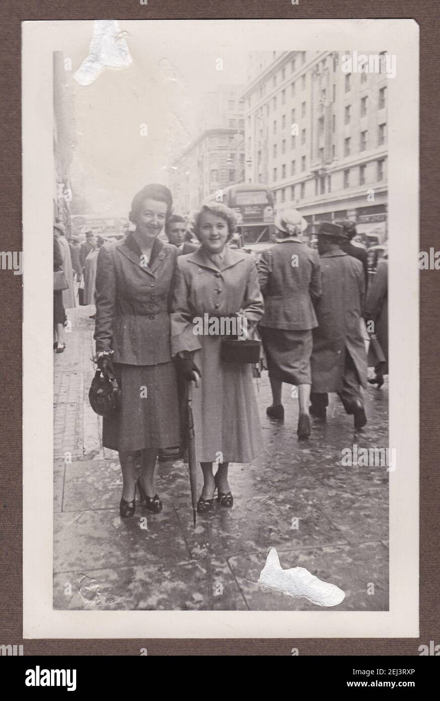 Vintage black and white photo of two women looking very smart in winter coats in busy street 1930s. Stock Photo