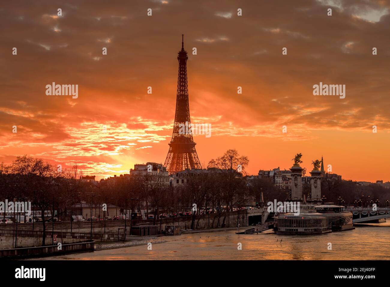 Paris, France - February 12, 2021: CItyscape of Paris in winter. Ships and brigde over Seine river with Eiffel tower in background and dramatic cloudy Stock Photo