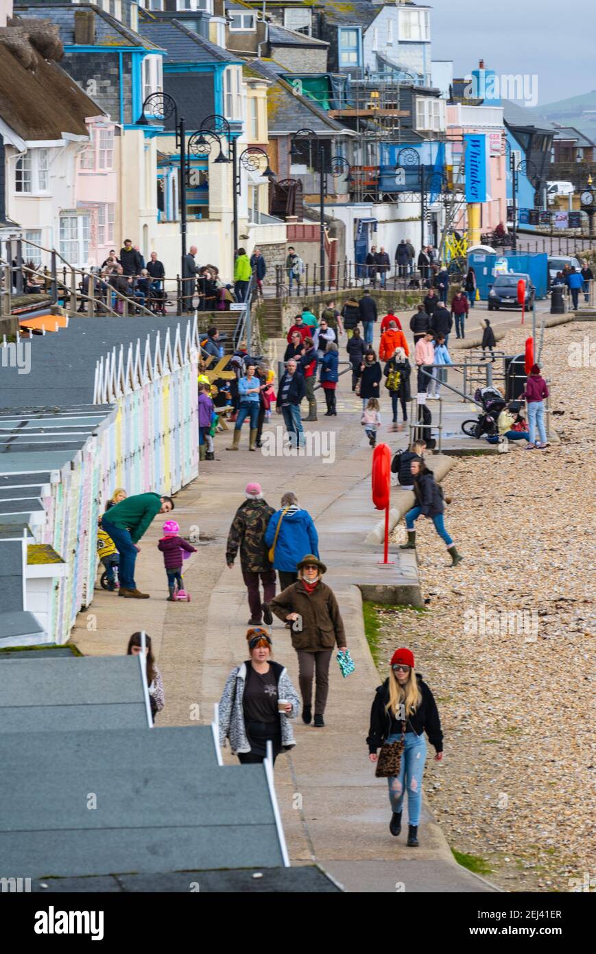 Lyme Regis, Dorset, UK. 21st Feb, 2021. UK Weather: People enjoy a warm and sunny Sunday afternoon on the beach at the seaside resort of Lyme Regis as the recent wet and gloomy weather clears bringing warmer, sunnier conditions next week. Credit: Celia McMahon/Alamy Live News Stock Photo