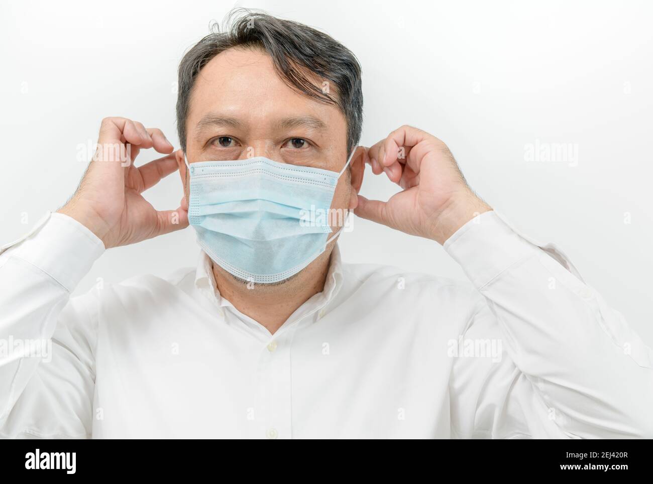 portrait of asian man in white shirt wearing face medical mask for ...