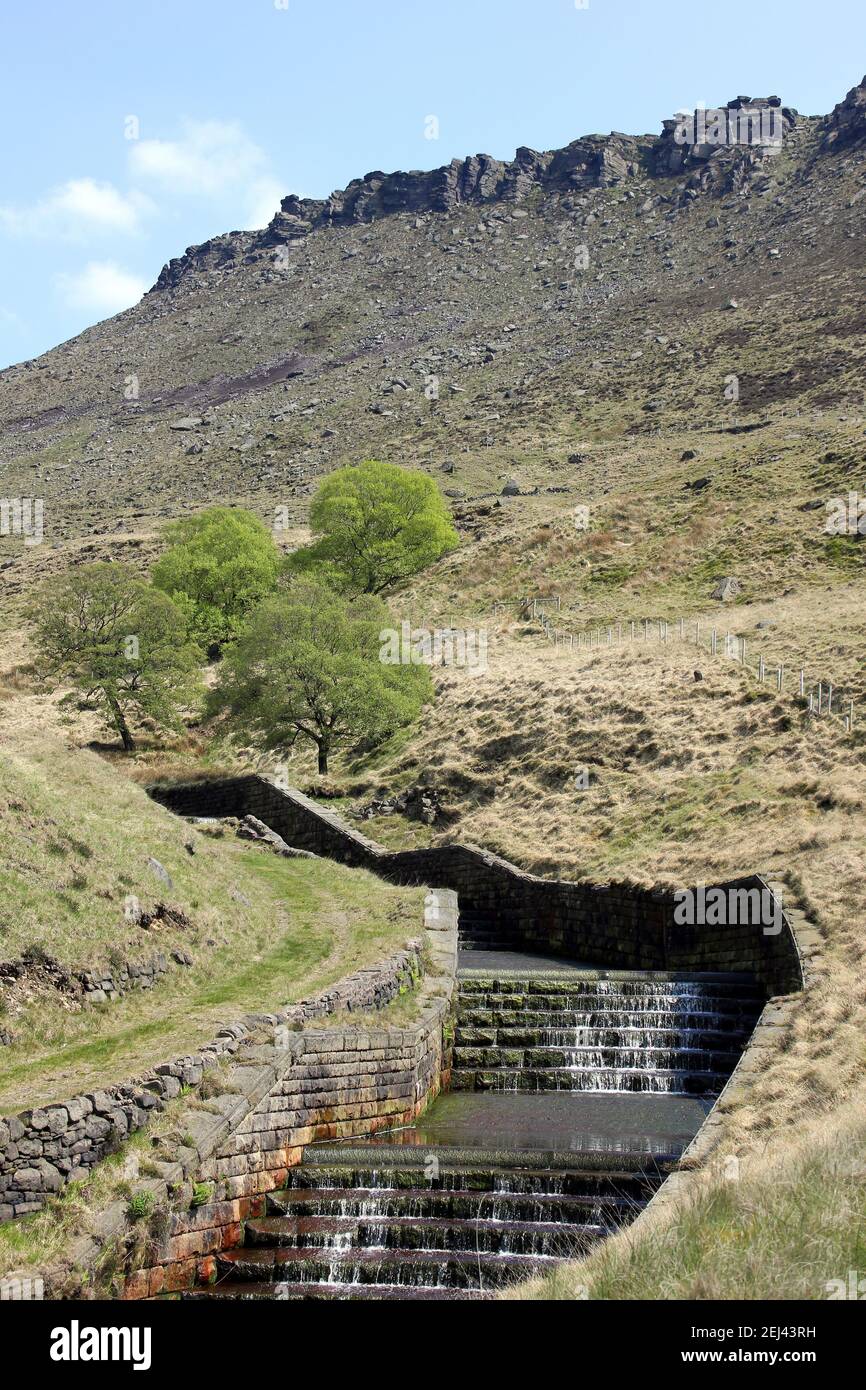 Ravenstones Crag and the water chute that drains into Dove Stone Reservoir Stock Photo