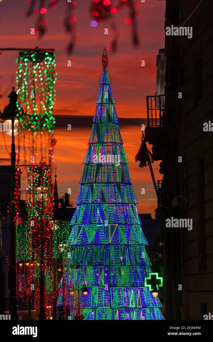 Illuminated Christmas tree rising in the center of the Puerta del Sol square in Madrid at dusk. Stock Photo
