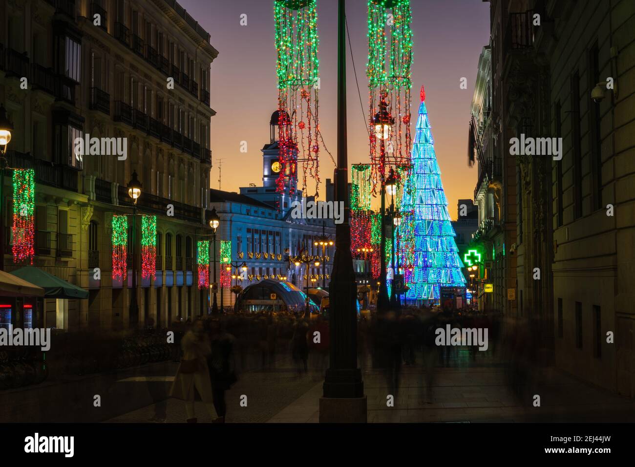 MADRID - DECEMBER 26, 2020: Crowds of people gather at the Puerta del Sol square in Madrid, Spain, with the traditional illuminated Christmas tree ris Stock Photo