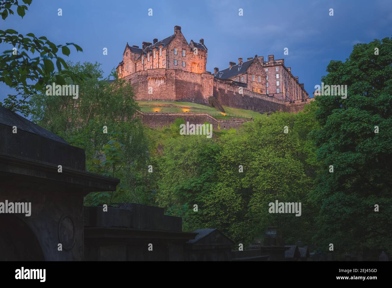 A spooky, moody view of the landmark Edinburgh Castle at night from St Cuthbert cemetery in Edinburgh, Scotland. Stock Photo