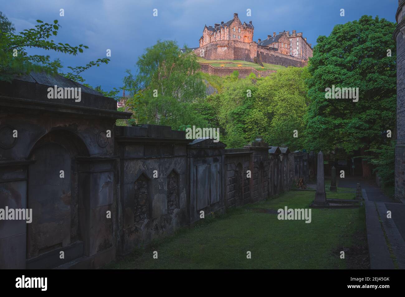 A spooky, moody view of the landmark Edinburgh Castle at night from St Cuthbert cemetery in Edinburgh, Scotland. Stock Photo