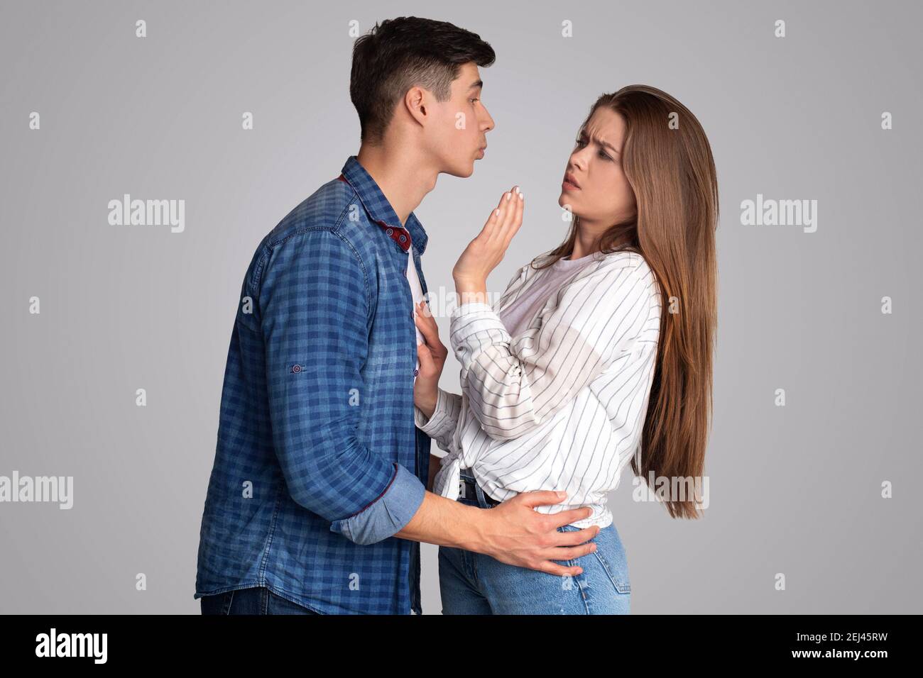 Young male tries to kiss upset lady, woman does not like molestation and does not want harassment Stock Photo