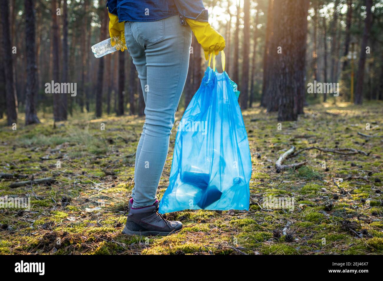 Keep our clean! Volunteer holding plastic bag and cleaning