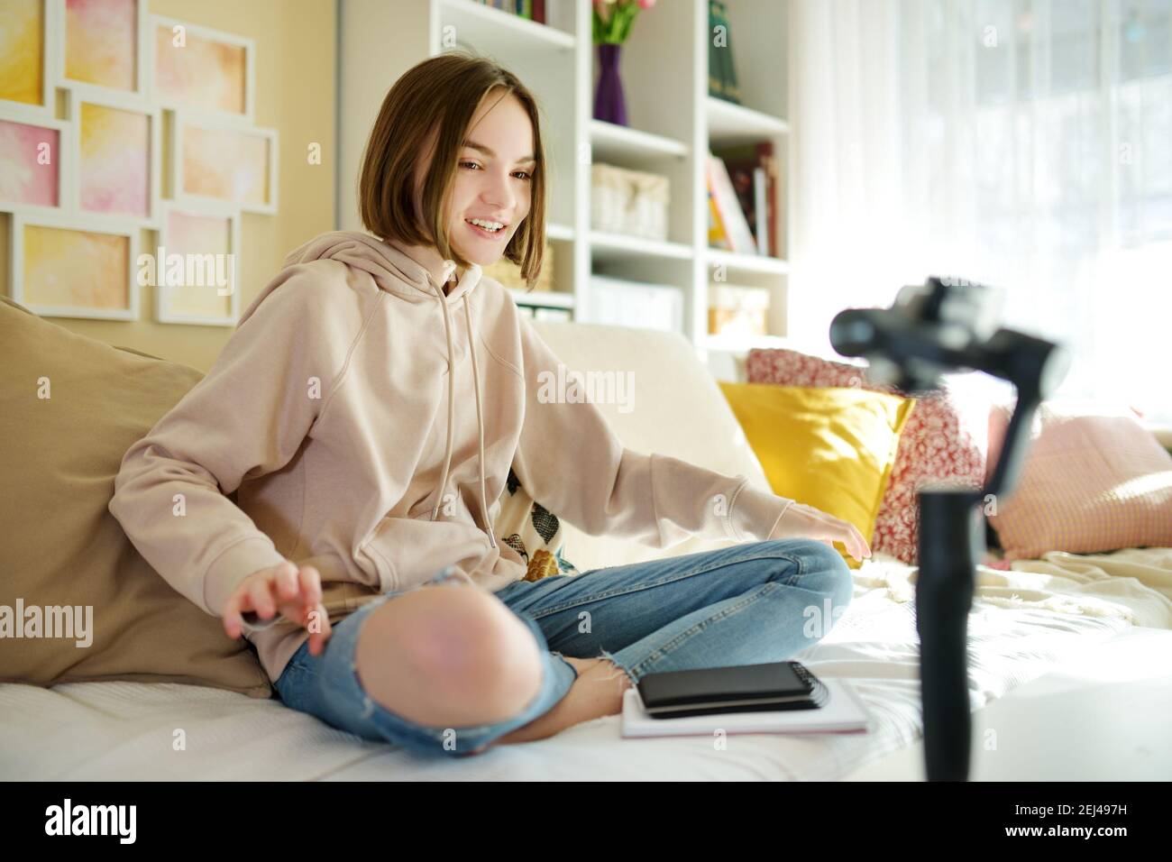 Beautiful teenage girl recording video blog with her smartphone. Young vlogger shooting vlog at home. Teen influencer creating content for her social Stock Photo