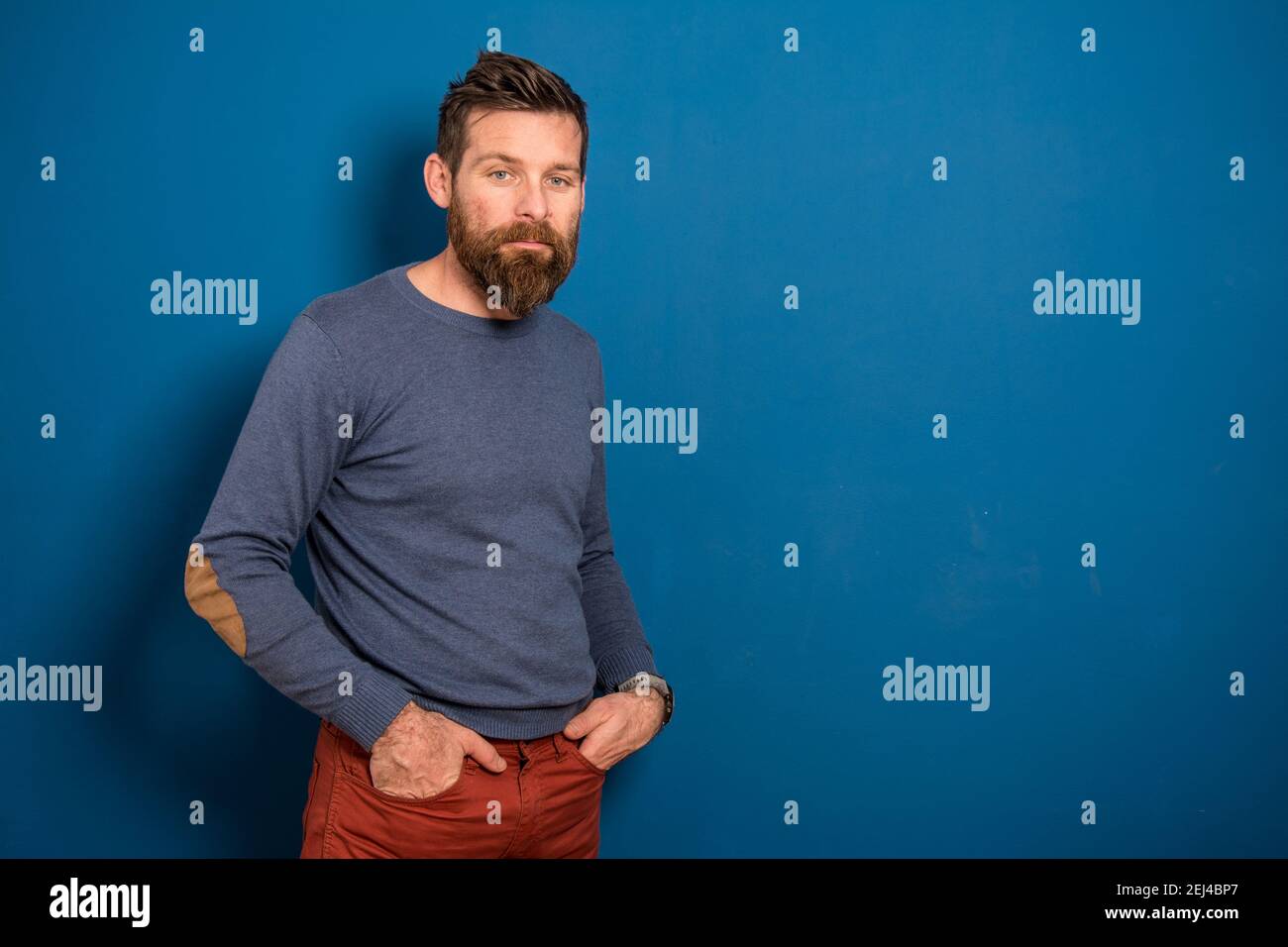 Portrait of a young man in a studio on a blue background Stock Photo ...