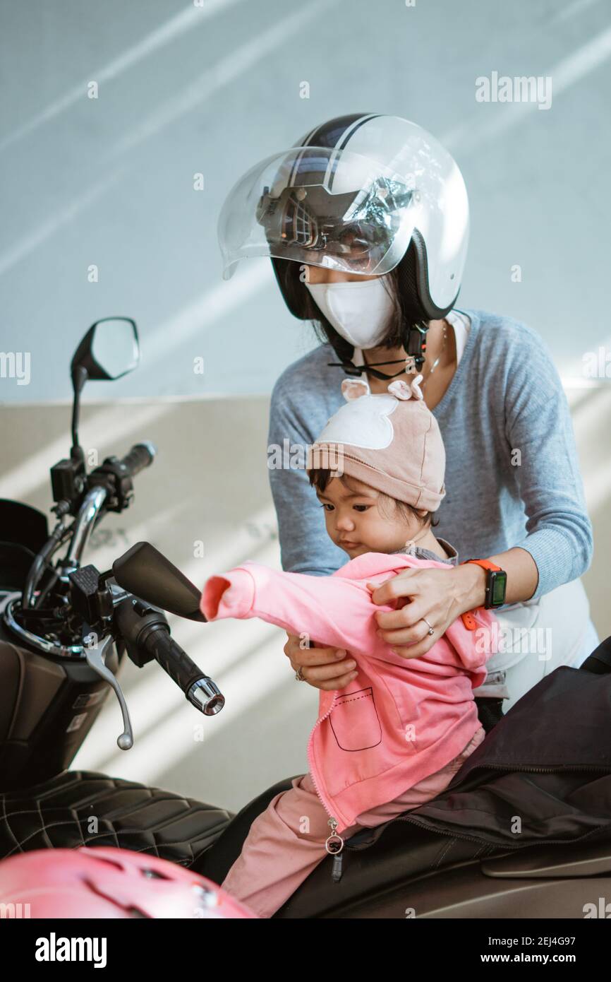 Mother helping child putting on a helmet hi res stock photography and images Alamy