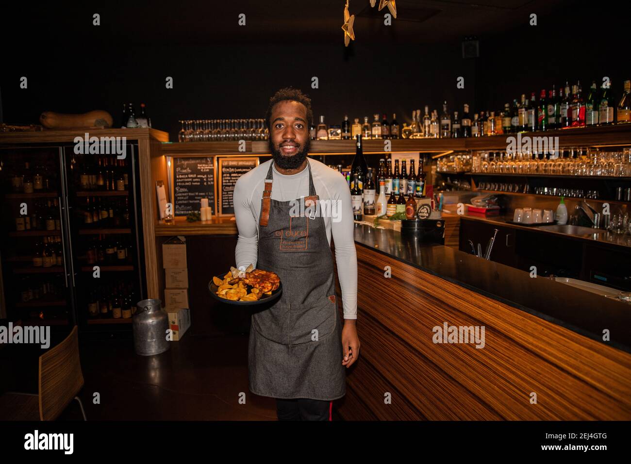 waiter brings the customer's order to the table Stock Photo