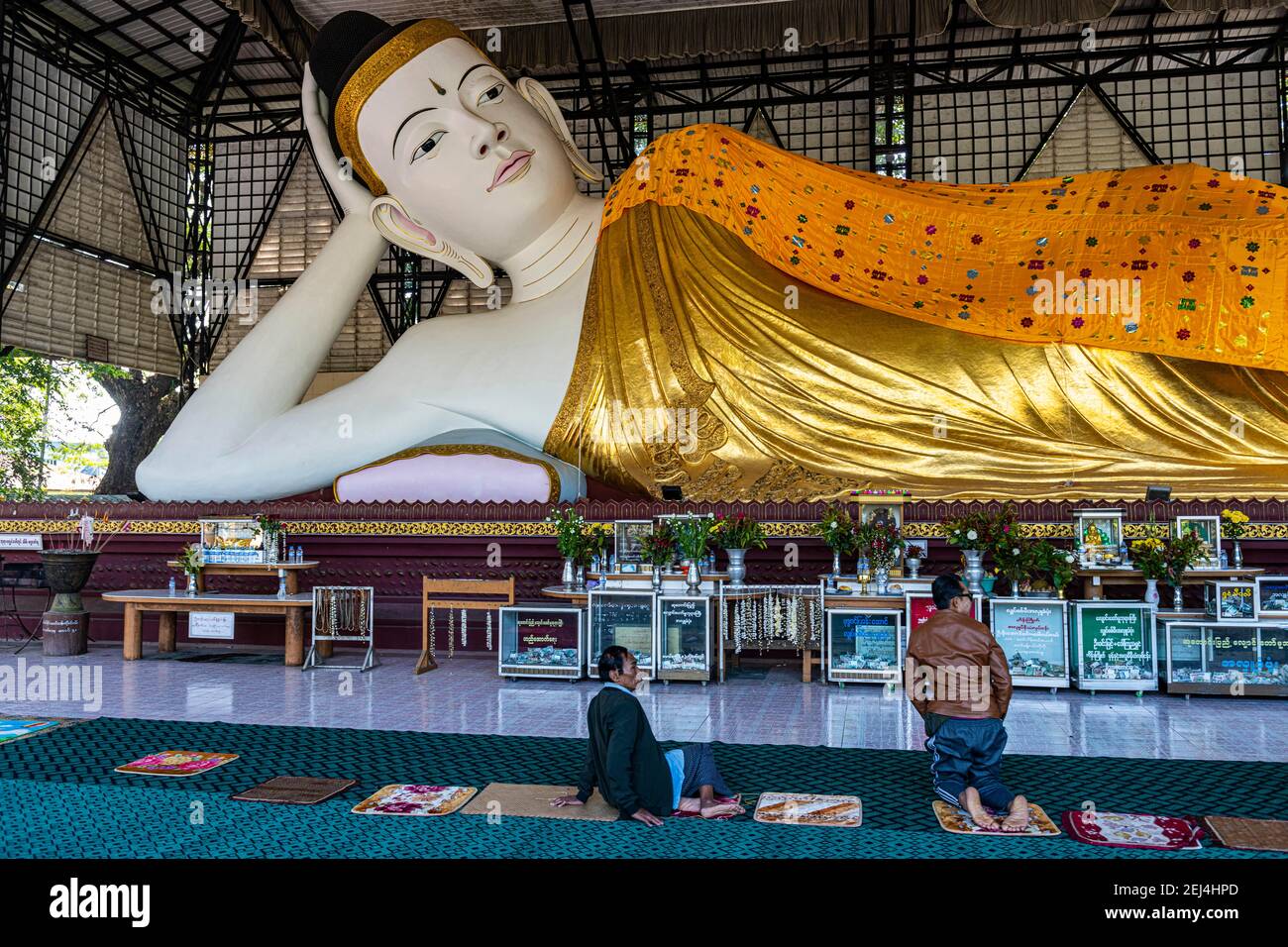 Pilgrims praying before a reclining buddha, Su taung pyi pagoda, Myitkyina, Kachin state, Myanmar Stock Photo