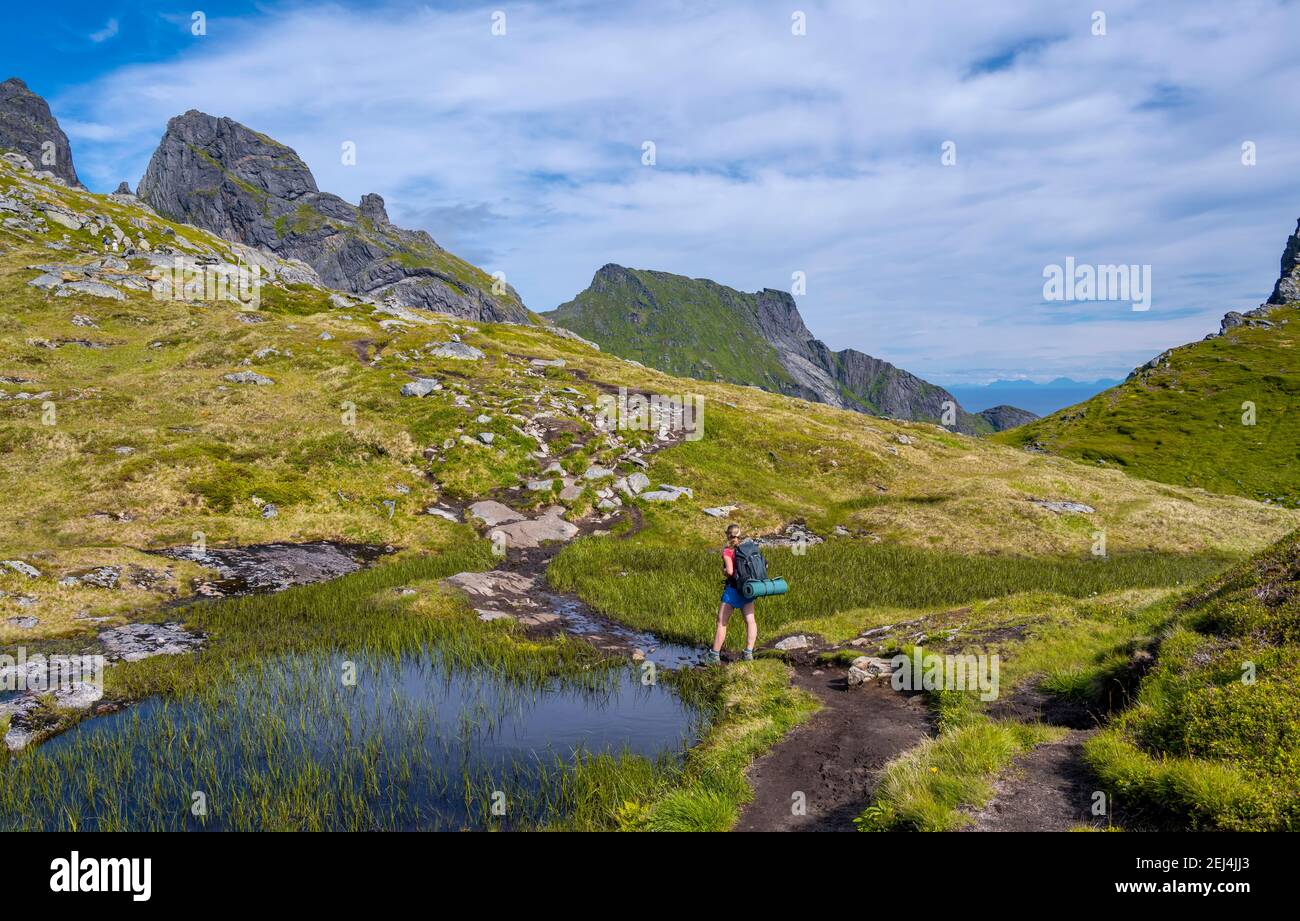 Hiker on hiking trail, hiking to Munkebu cabin, mountains, near Sorvagen, Moskenesoya, Lofoten, Nordland Stock Photo