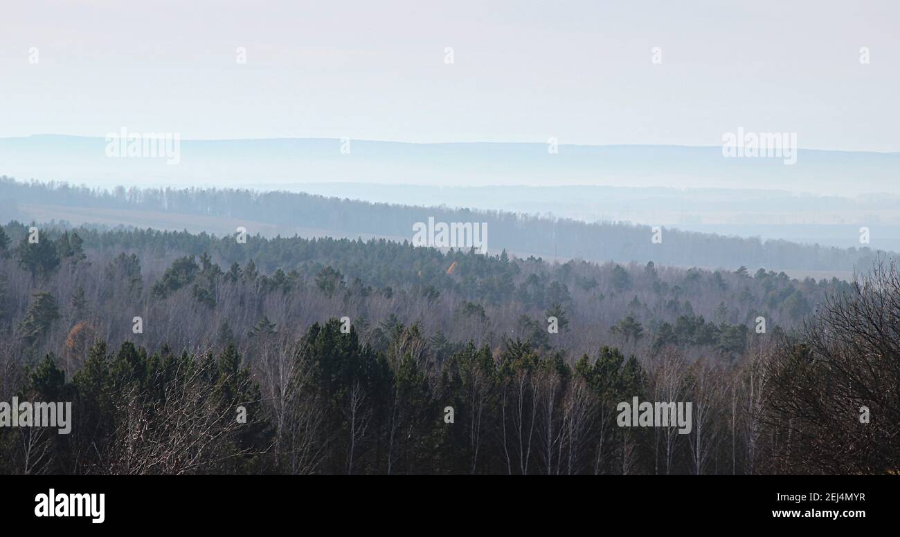 View of wooded hills from high ground in the early morning. Stock Photo