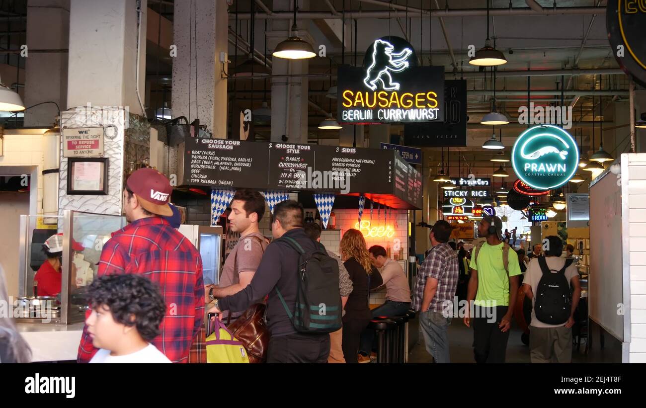 LOS ANGELES, CALIFORNIA, USA - 30 OCT 2019: Grand central market street lunch shops with diversity of glowing retro neon signs. Multiracial people on Stock Photo