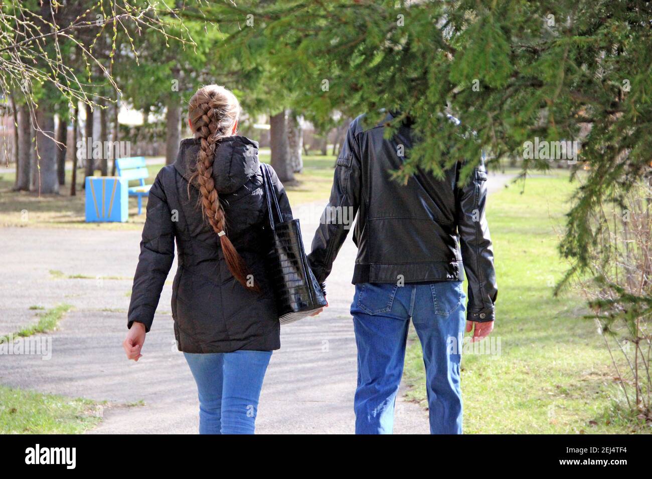 A young man and a girl with a scythe are walking along a deserted street by the day. Stock Photo