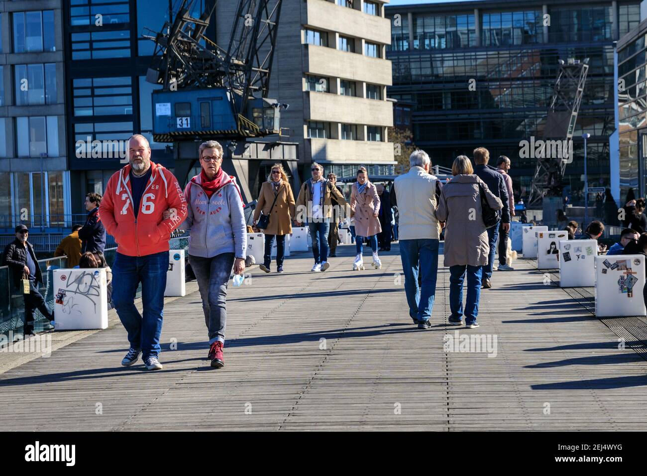 Düsseldorf, NRW, 2021. People enjoy their Sunday afternoon in beautiful warm sunshine with temperatures up to 18 degrees in the popular MedienHafen (media harbour) district, a redeveloped area by the river Rhine hosting media companies, offices, entertainment, restaurants and leisure facilities in Düsseldorf, the capital of Germany's most populous state of North Rhine-Westphalia. Credit: Imageplotter/Alamy Live News Stock Photo