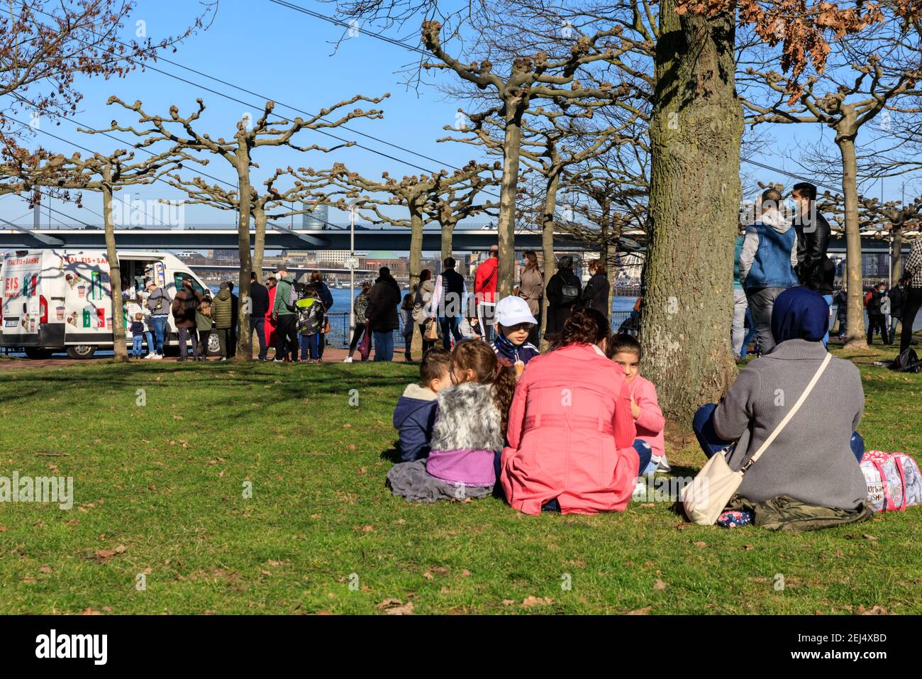 Düsseldorf, NRW, 2021. People enjoy their Sunday afternoon with picnicks in beautiful warm sunshine with temperatures up to 18 degrees in the popular MedienHafen (media harbour) district, a redeveloped area by the river Rhine hosting media companies, offices, entertainment, restaurants and leisure facilities in Düsseldorf, the capital of Germany's most populous state of North Rhine-Westphalia. Credit: Imageplotter/Alamy Live News Stock Photo