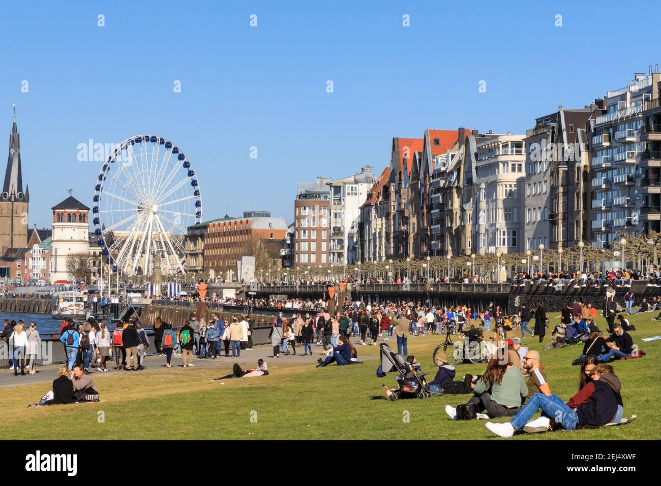 Düsseldorf, NRW, 2021. People enjoy their Sunday afternoon in beautiful warm sunshine with temperatures up to 18 degrees, strolling along the River Rhine and relaxing on the lawn in Düsseldorf, the capital of Germany's most populous state of North Rhine-Westphalia. Credit: Imageplotter/Alamy Live News Stock Photo