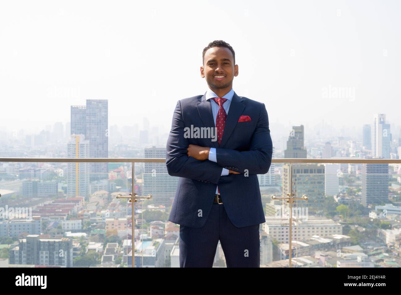 Portrait of handsome young African businessman wearing suit smiling ...