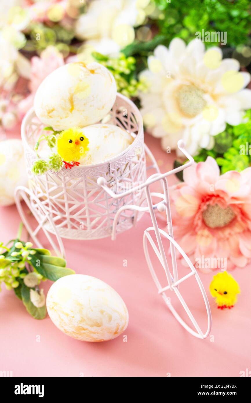 Easter floral background. Spring flowers gerbera with easter eggs on pink background. Stock Photo