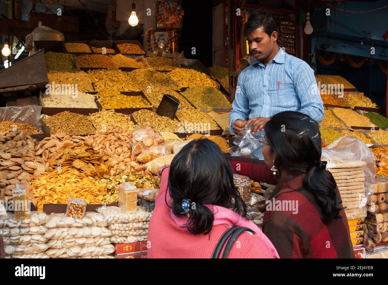 A vendor sells namkeen to customers at this food statl in Lucknow Stock Photo