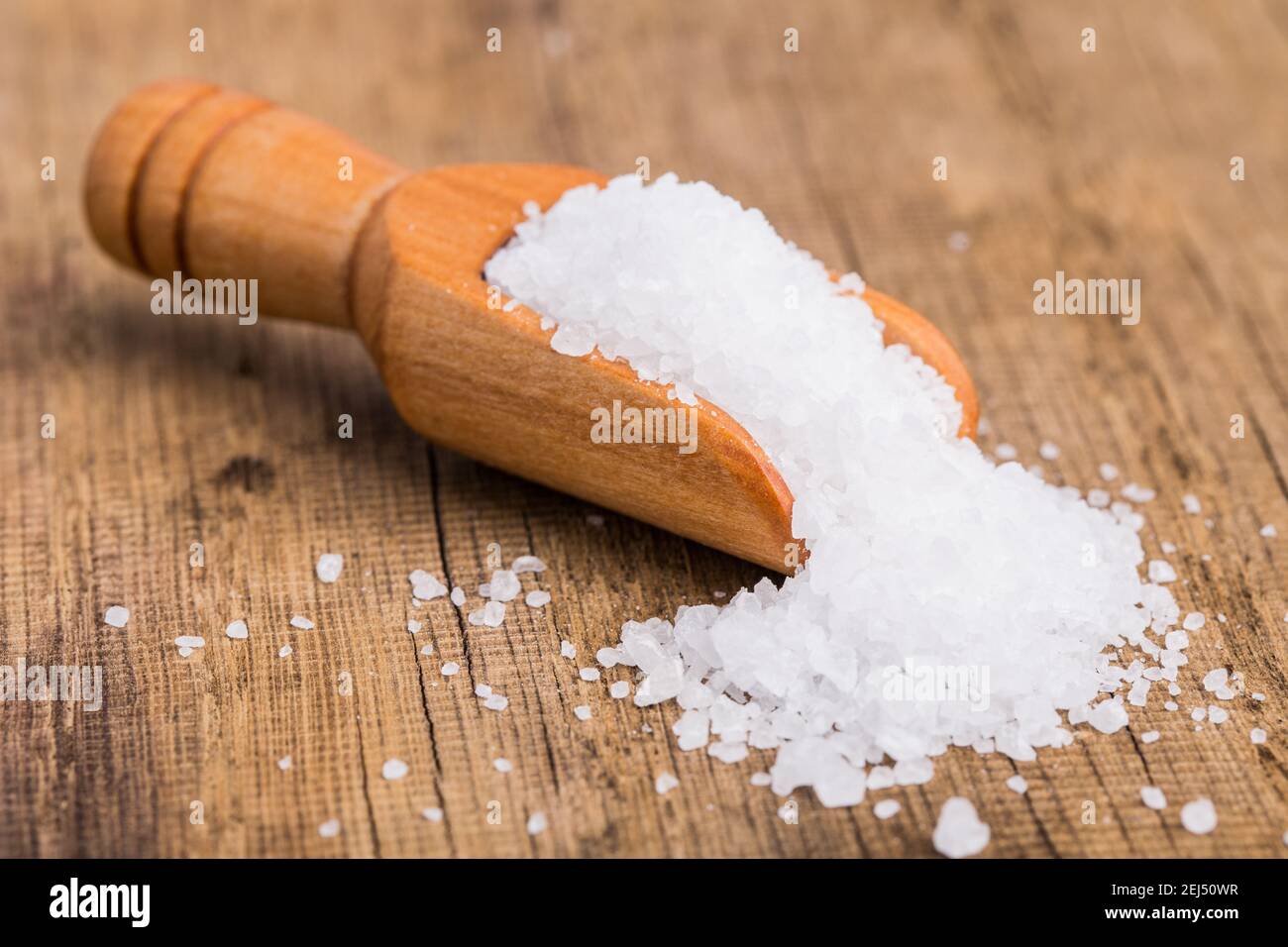 Coarse salt in a wooden scoop Stock Photo