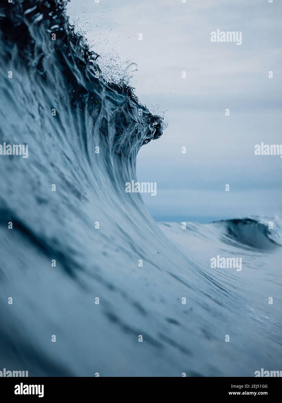 Perfect ocean waves with blue water cloudy sky. Stock Photo