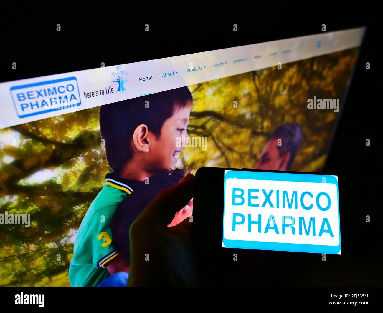 Person holding mobile phone with logo of Bangladeshi company Beximco Pharmaceuticals Ltd on screen in front of web page. Focus on cellphone display. Stock Photo